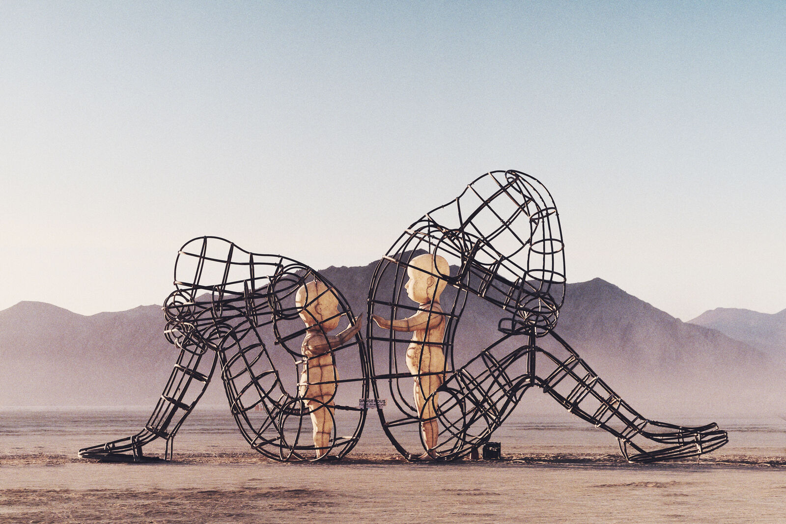 Love sculpture by Alexander Milov at Burning Man - two adults with inner children reaching for each other