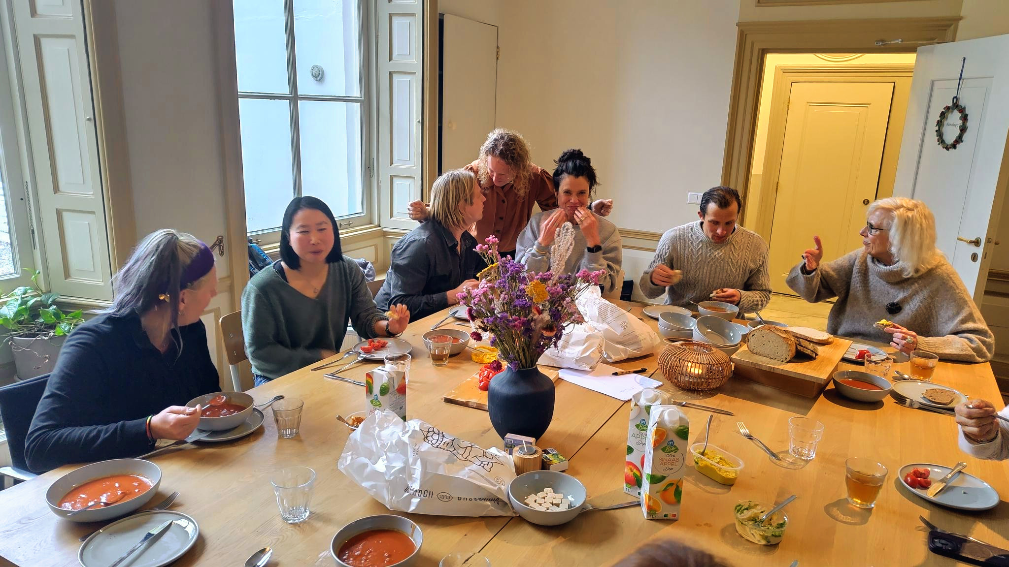 Participants sharing lunch around a long table between two workshop sessions